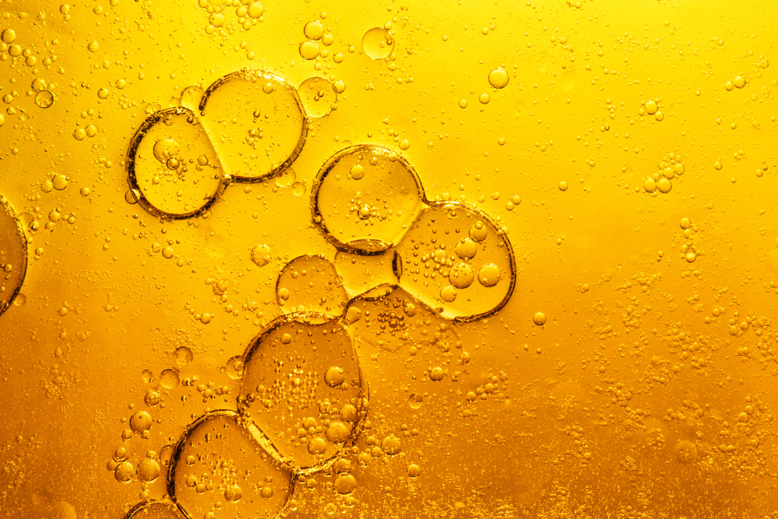 A close up of bubbles in a yellow liquid