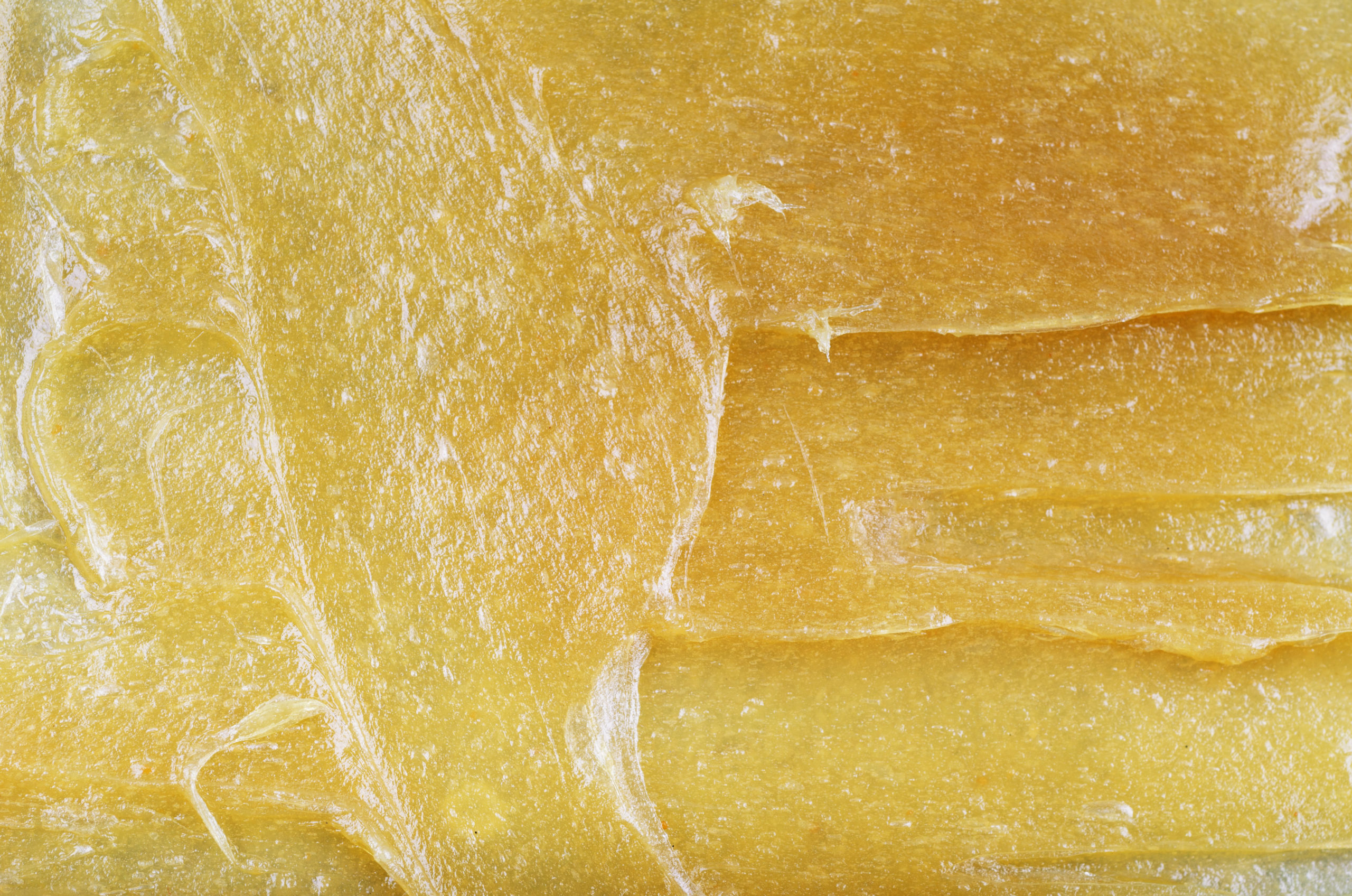 A close up of a thick yellow substance with white spots